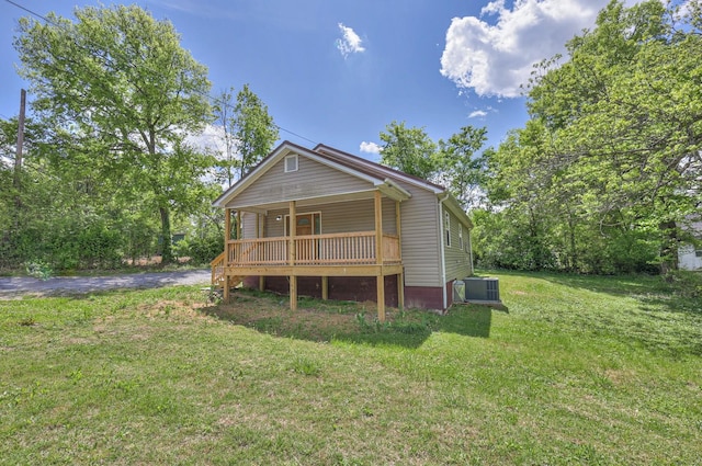 view of front of property with central air condition unit, covered porch, and a front yard