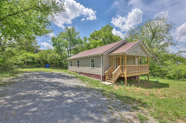 view of front facade with covered porch, crawl space, and metal roof