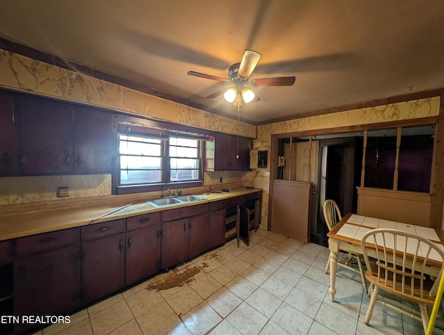 kitchen with a sink, a ceiling fan, light tile patterned floors, and light countertops