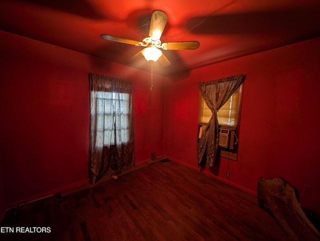 empty room with baseboards, ceiling fan, wood finished floors, and cooling unit