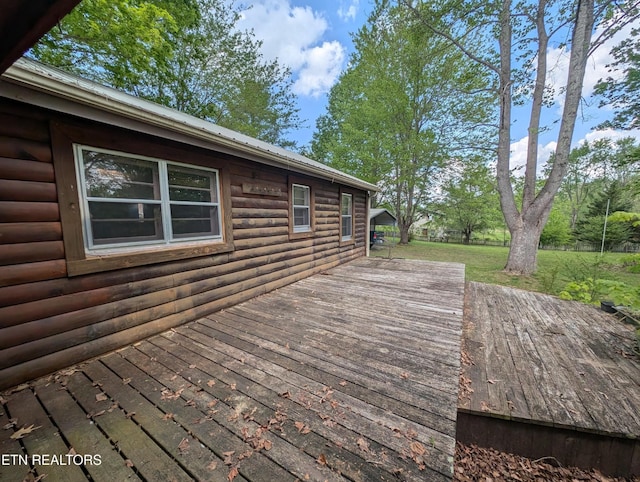 wooden deck featuring a lawn