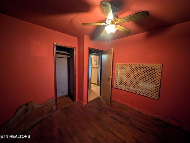 unfurnished bedroom with a ceiling fan, baseboards, wood finished floors, and a closet