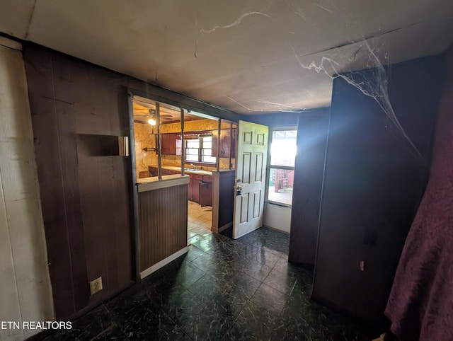 interior space with wooden walls and dark floors