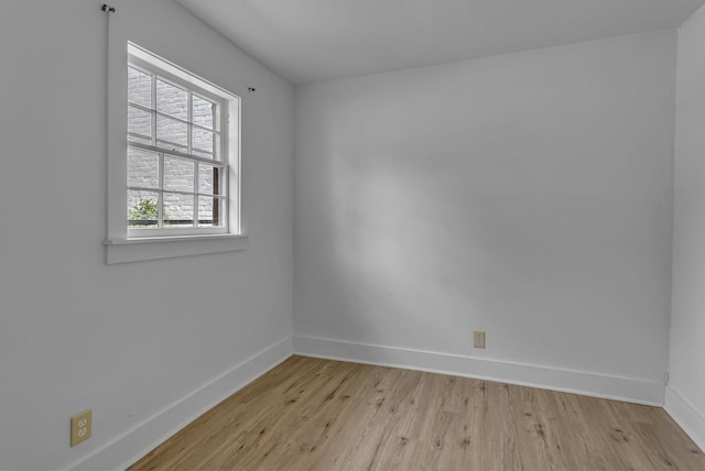 empty room featuring baseboards and light wood-style floors