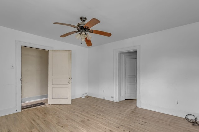 empty room with a ceiling fan and light wood finished floors