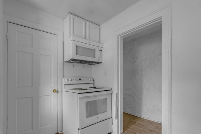 kitchen featuring light countertops, light wood finished floors, white appliances, and white cabinetry