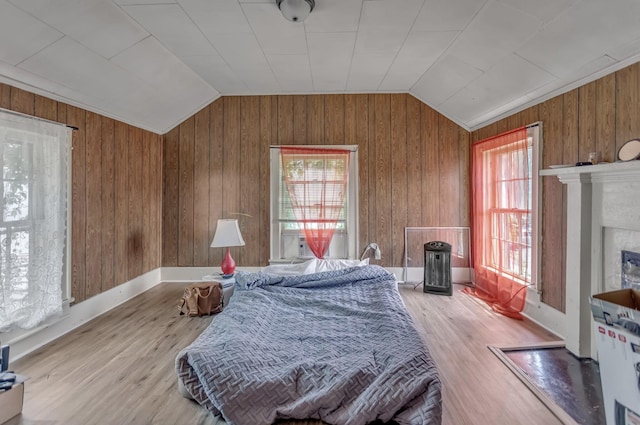 bedroom featuring vaulted ceiling, multiple windows, and wood finished floors