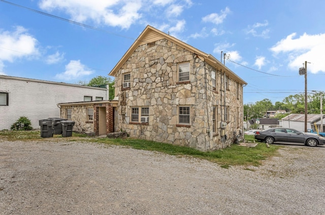 back of property featuring stone siding