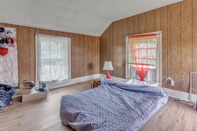 bedroom featuring lofted ceiling, wooden walls, multiple windows, and cooling unit