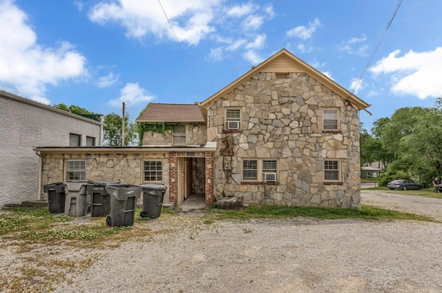 rear view of property featuring stone siding