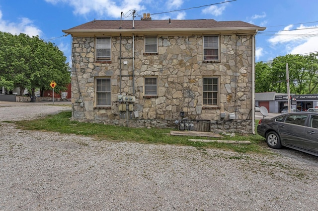 rear view of house featuring stone siding