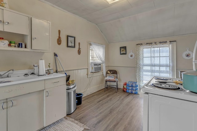 kitchen with white range with electric stovetop, cooling unit, light countertops, light wood-style flooring, and a wainscoted wall