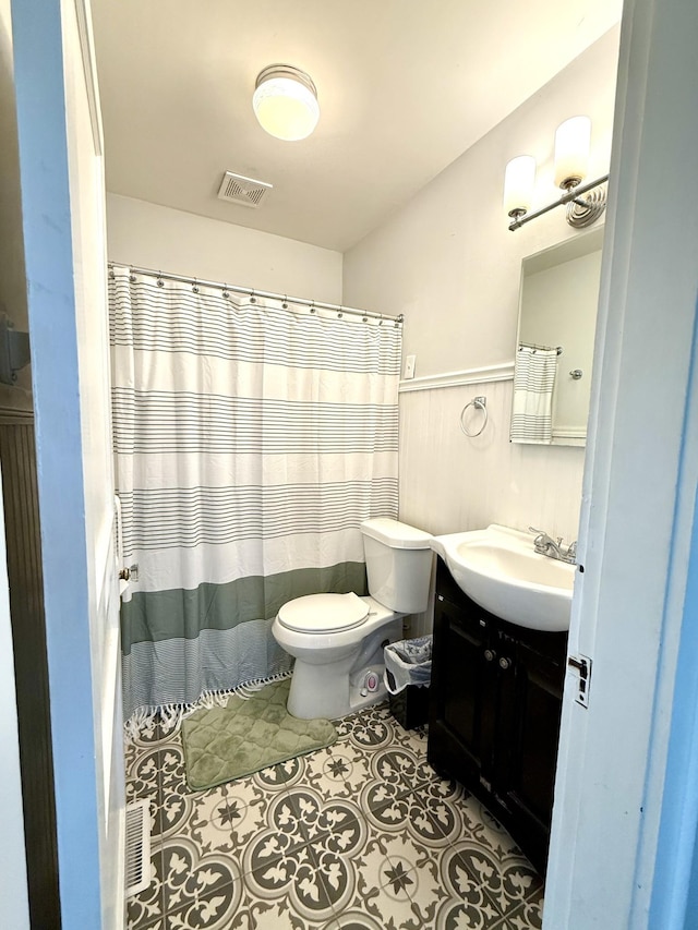 bathroom featuring toilet, visible vents, tile patterned flooring, and vanity