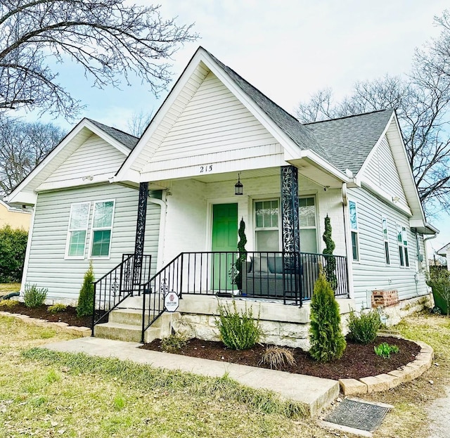 bungalow with a porch and a shingled roof
