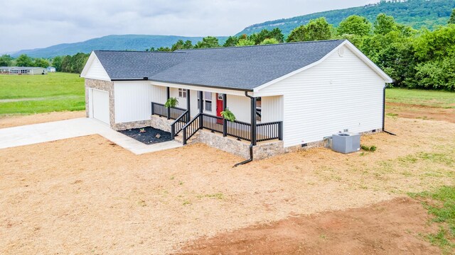 ranch-style house featuring covered porch, crawl space, driveway, central AC unit, and a shingled roof