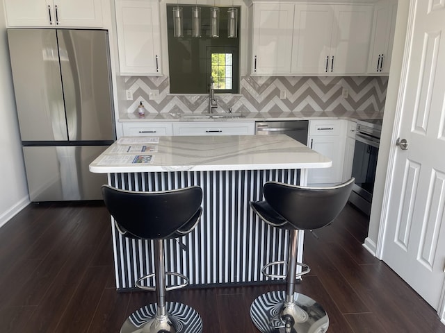 5170 Hickory Hollow Pkwy Unit 223, Antioch, TN 37013 - kitchen featuring white cabinets, appliances with stainless steel finishes, a sink, a breakfast bar area, and dark wood-type flooring
