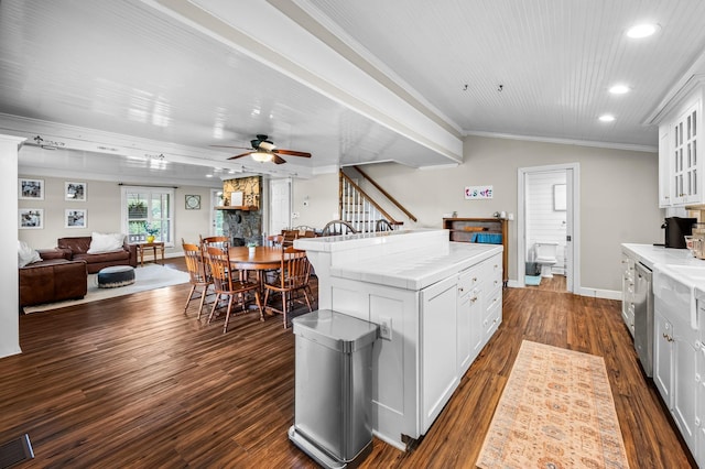 kitchen with a ceiling fan, ornamental molding, recessed lighting, glass insert cabinets, and stainless steel dishwasher