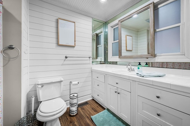bathroom featuring wood finished floors, toilet, vanity, and crown molding