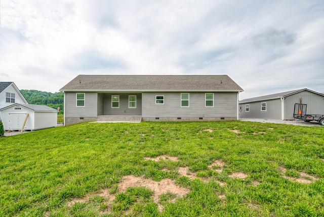 back of house with a storage shed, crawl space, an outbuilding, a patio area, and a yard