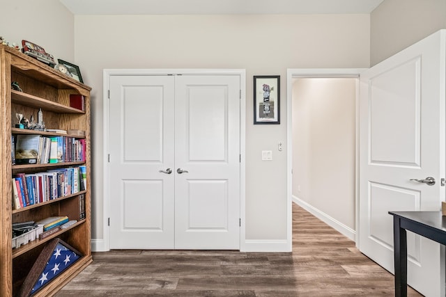 interior space featuring baseboards and wood finished floors