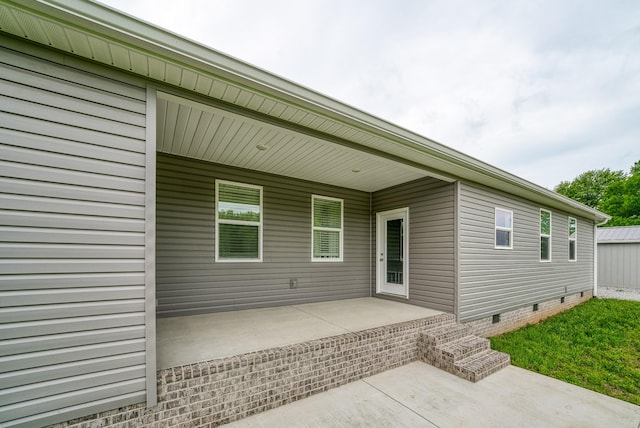 rear view of house featuring a patio and crawl space
