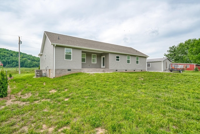back of house featuring central AC unit, a yard, and crawl space
