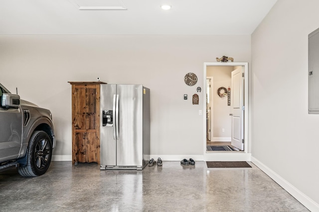 garage with stainless steel fridge and baseboards