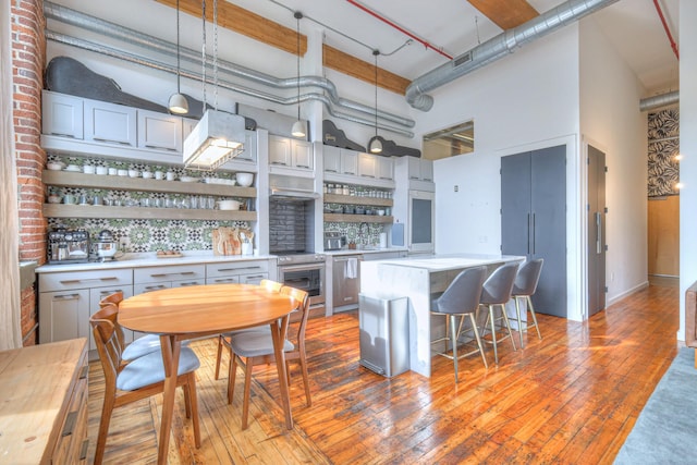 kitchen with light countertops, electric stove, open shelves, and a towering ceiling