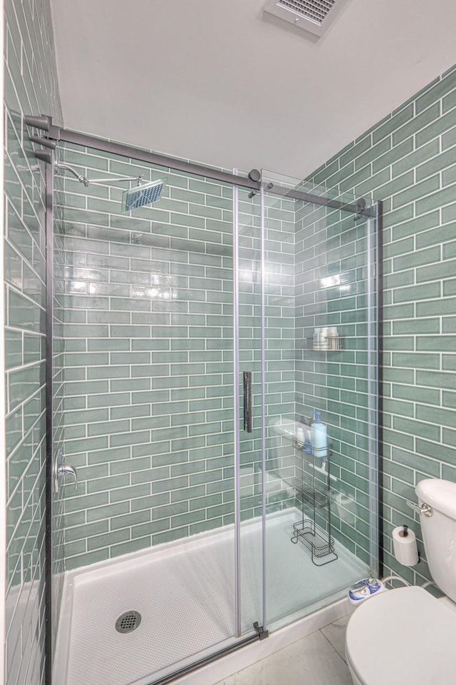 full bath with tile patterned flooring, visible vents, toilet, and a shower stall