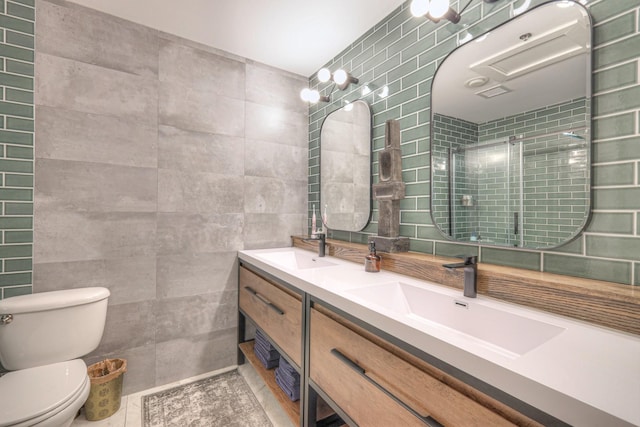 full bath featuring a sink, tile walls, a stall shower, and toilet