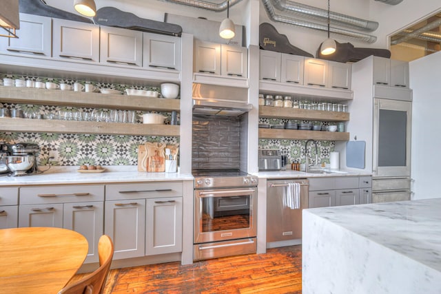bar featuring light wood-type flooring, a sink, tasteful backsplash, and stainless steel appliances