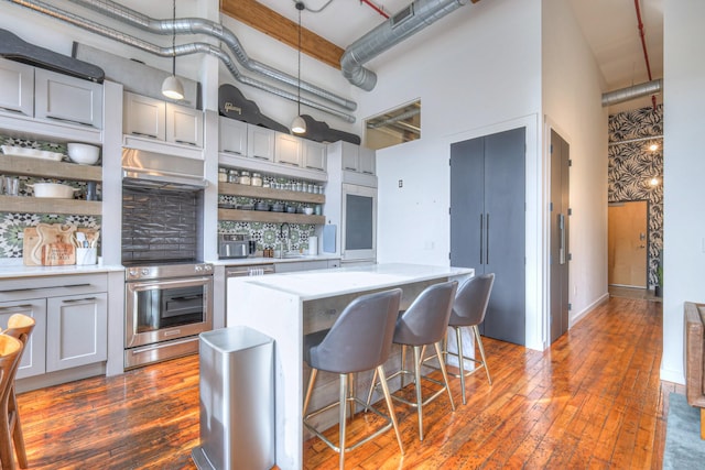 kitchen with electric stove, open shelves, a towering ceiling, and light countertops