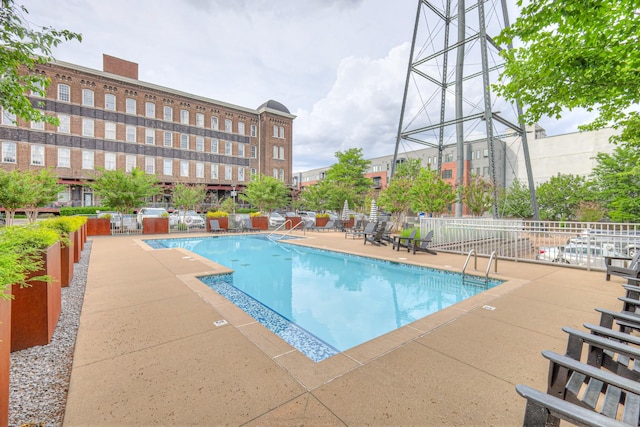 pool with a patio and fence