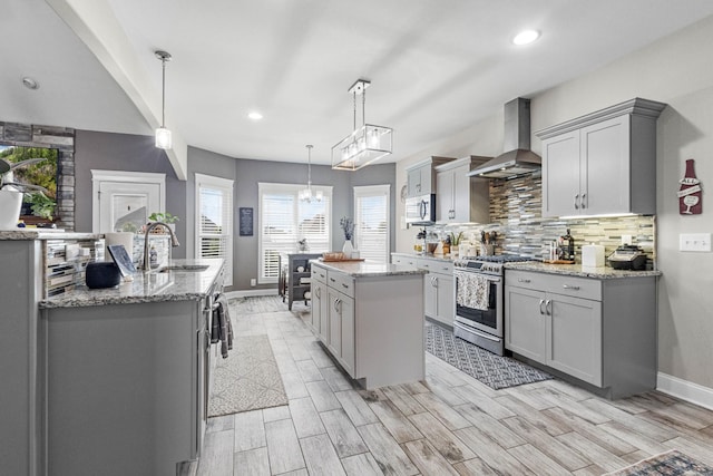 1132 Upland Ter, Clarksville, TN 37043 - kitchen featuring a center island, wall chimney exhaust hood, gray cabinets, a sink, and stainless steel appliances