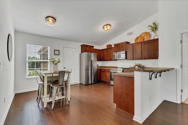3005 Aruna Ct, Spring Hill, TN 37174 - kitchen with stainless steel appliances, a kitchen bar, a peninsula, baseboards, and dark wood-type flooring
