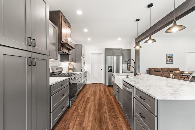kitchen featuring stainless steel appliances, a sink, and gray cabinets