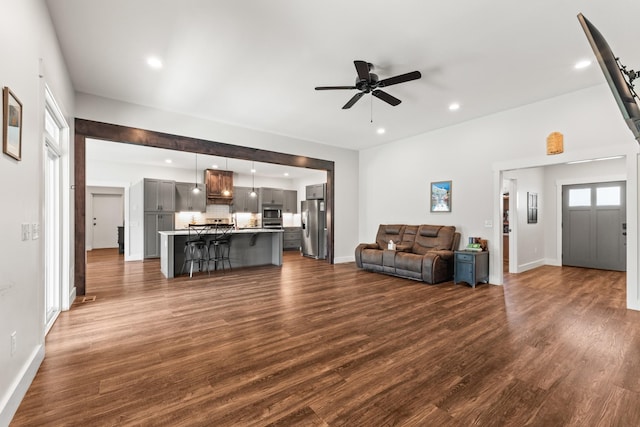 living area featuring recessed lighting, a ceiling fan, dark wood finished floors, and baseboards