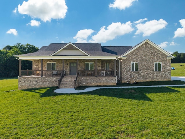view of front of home with covered porch, brick siding, and a front yard