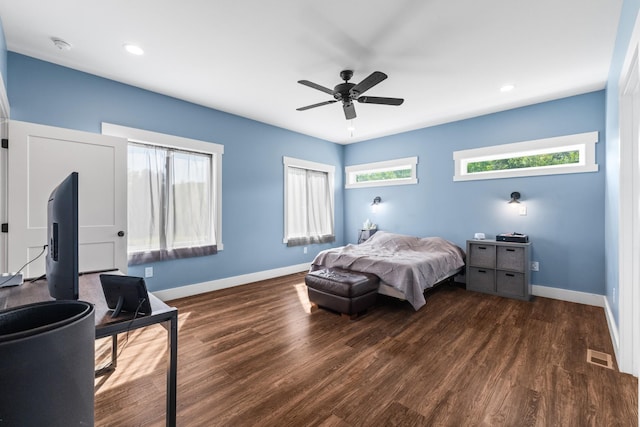 bedroom featuring visible vents, a ceiling fan, dark wood finished floors, and baseboards