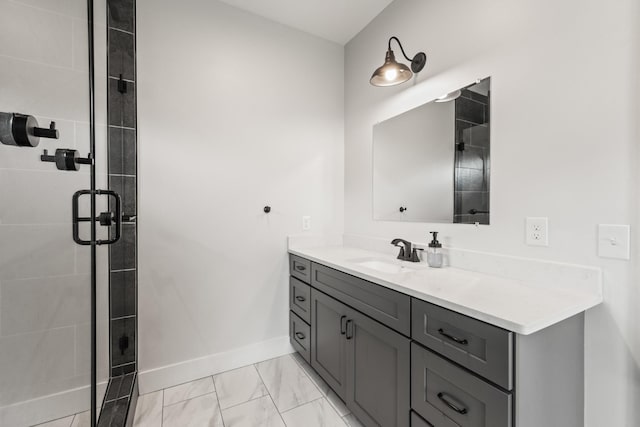 full bath featuring vanity, baseboards, marble finish floor, and a stall shower
