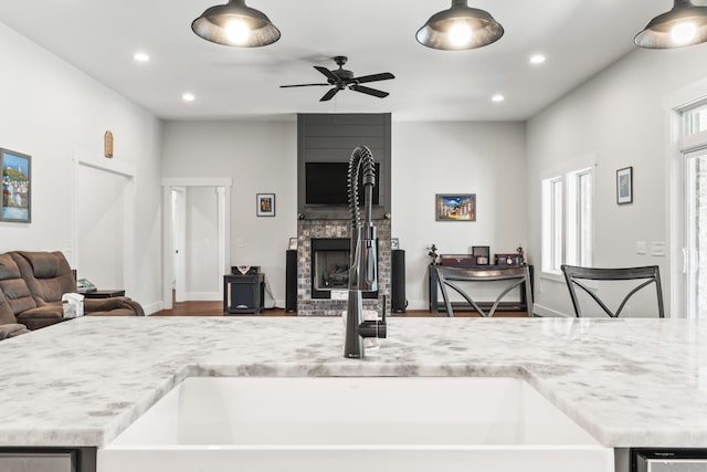kitchen with ceiling fan, a sink, a fireplace, recessed lighting, and open floor plan