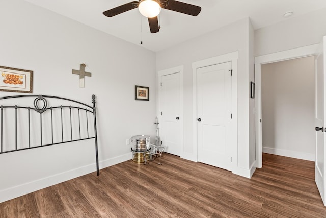 unfurnished bedroom with a ceiling fan, baseboards, and wood finished floors