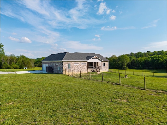 exterior space featuring concrete driveway, a lawn, an attached garage, and fence