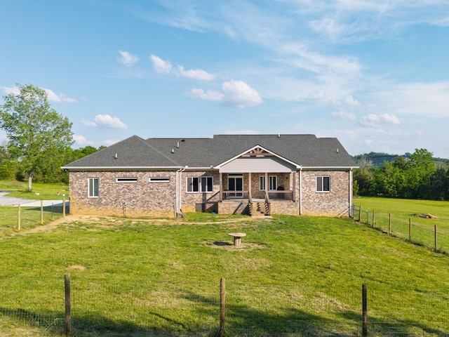 rear view of house with fence private yard, a lawn, and brick siding