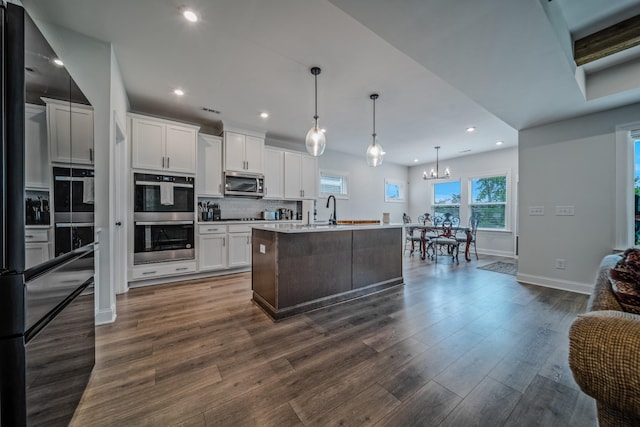 1055 Inez Dr, Smyrna, TN 37167 - kitchen with appliances with stainless steel finishes, baseboards, a sink, a chandelier, and dark wood finished floors