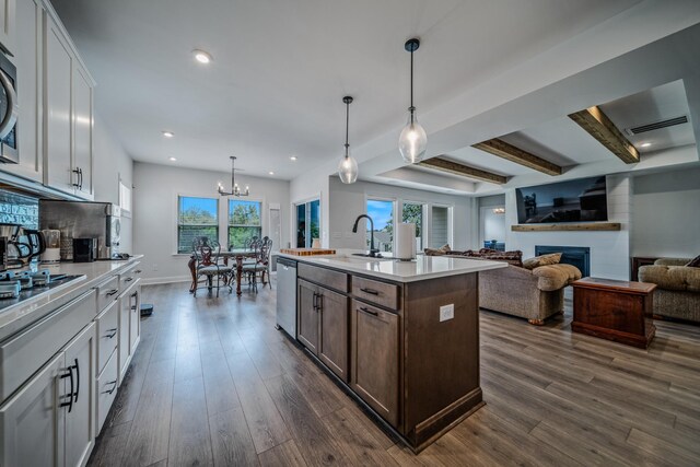 1055 Inez Dr, Smyrna, TN 37167 - kitchen with a sink, a fireplace, light countertops, stainless steel dishwasher, and dark wood-style flooring