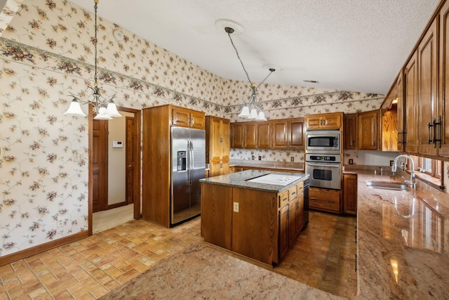 1314 Huntington Dr, Columbia, TN 38401 - kitchen with brown cabinets, appliances with stainless steel finishes, a sink, a center island, and wallpapered walls