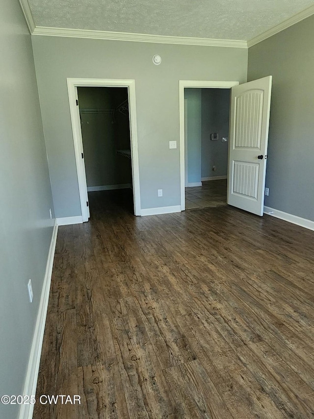 85 Neshova Ln, Henderson, TN 38340 - unfurnished bedroom featuring baseboards, a walk in closet, and dark wood-type flooring