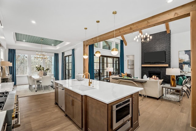 7258 Murrel Dr, Franklin, TN 37064 - kitchen with an inviting chandelier, a sink, light wood-style flooring, and a fireplace