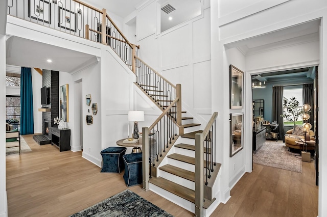 7258 Murrel Dr, Franklin, TN 37064 - staircase with a high ceiling, baseboards, wood finished floors, visible vents, and ornamental molding